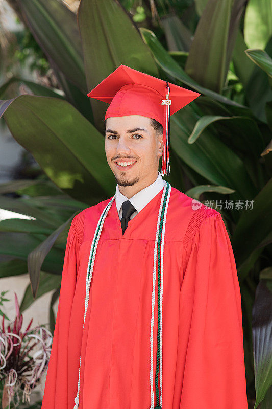 2023年，佛罗里达州棕榈滩，一位18岁的古巴裔美国人，穿着得体的棕色头发和棕色眼睛，穿着西装和领带，戴着红色毕业帽和长袍，三流苏的高中毕业生