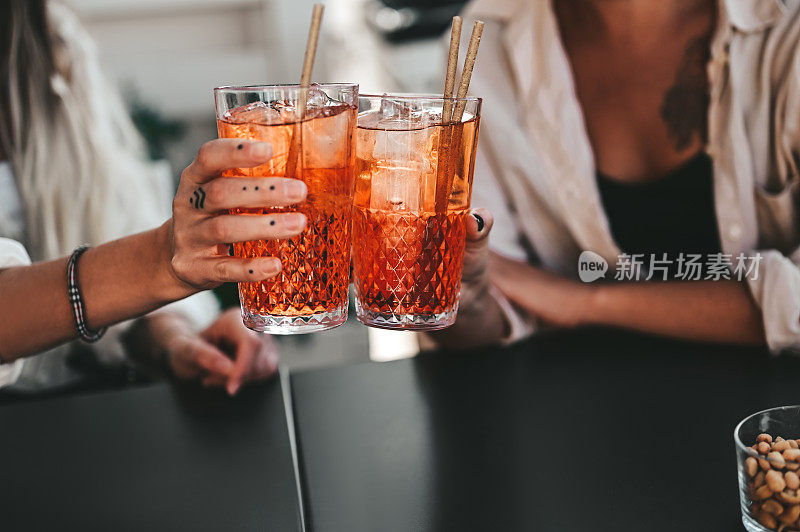 女友们用橙色鸡尾酒敬酒。