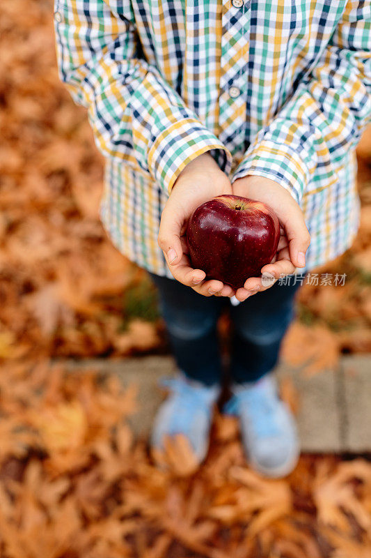 小孩手拿苹果的高角度照片