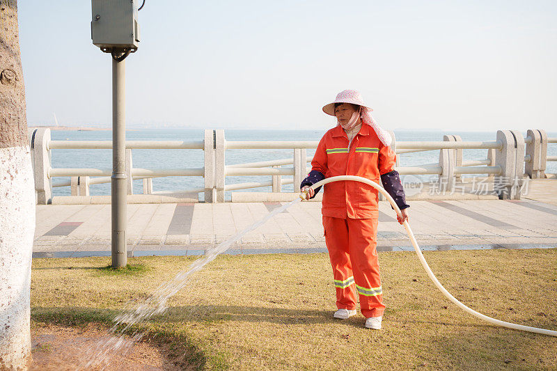 给植物浇水的老年工人