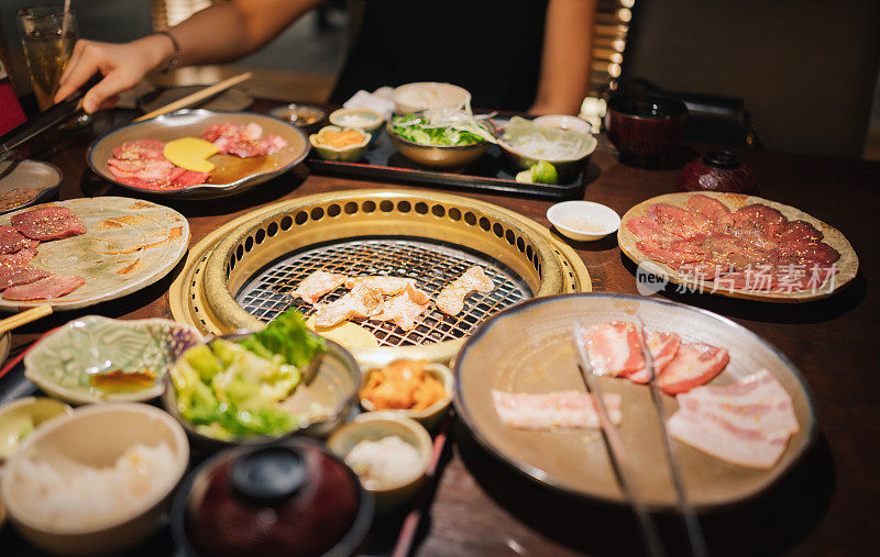 俯视图年轻的亚洲办公室y世代女商人享受烧烤A5和牛日本食品与快乐的情绪在当地的日本餐馆