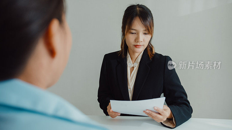 年轻的亚洲女性通过面试，坐在办公室的人力资源经理面前。人力资源，招聘机构。