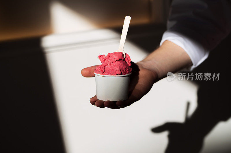 一勺樱桃冰淇淋，装在有阴影的杯子里