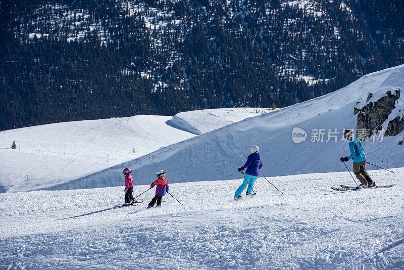 一家人在滑雪场滑下斜坡