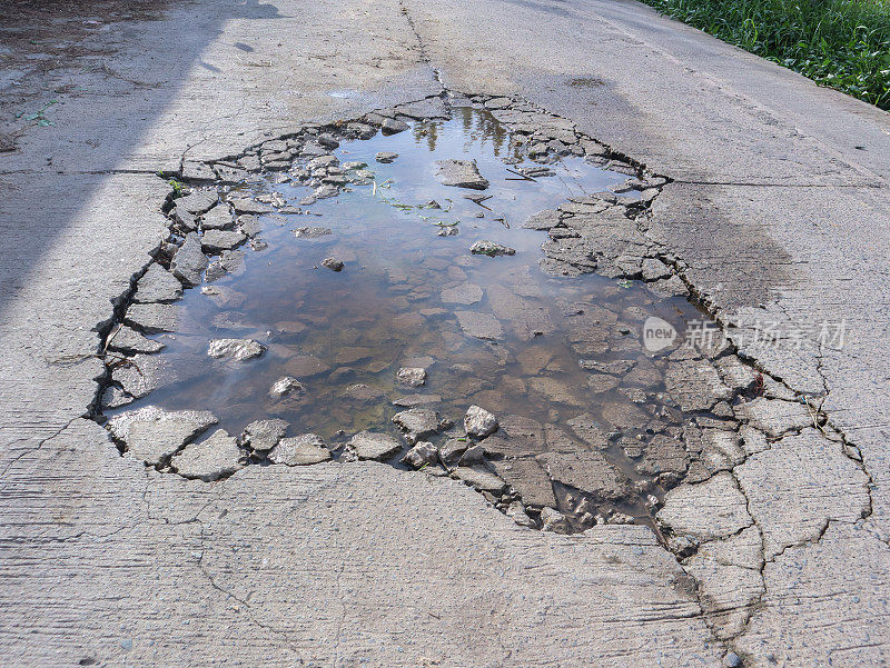 损坏的混凝土道路造成水坑。由水泥制成的街道插画概念并不耐用
