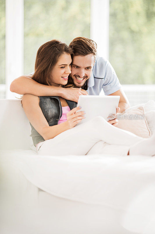夫妇在家里使用数码平板电脑。