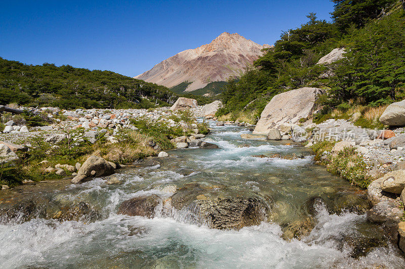 一条高山溪流在南美洲阿根廷巴塔哥尼亚的巴塔哥尼亚安第斯山脉强劲流动