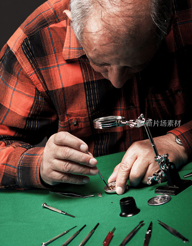老人正在修理旧怀表