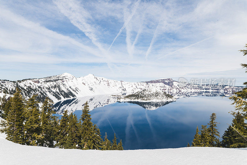 一个巨大的自然湖被雪山包围，在阳光和蓝天下闪闪发光