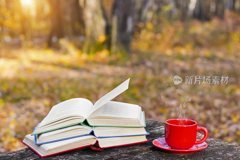 一堆彩色的书和一杯热咖啡