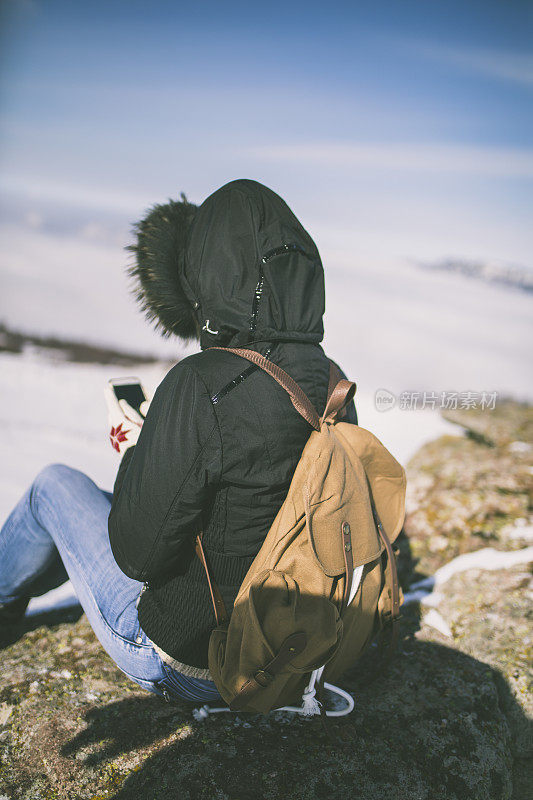 女孩在户外的山峰上发短信。