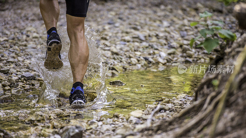 一名男子跑步时踩进小溪溅起水花