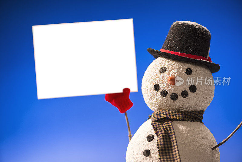 微笑的雪人戴着大礼帽，举着空白的白色标志
