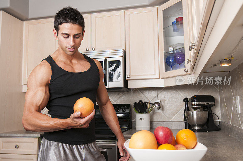 一个运动员在厨房拿着葡萄柚
