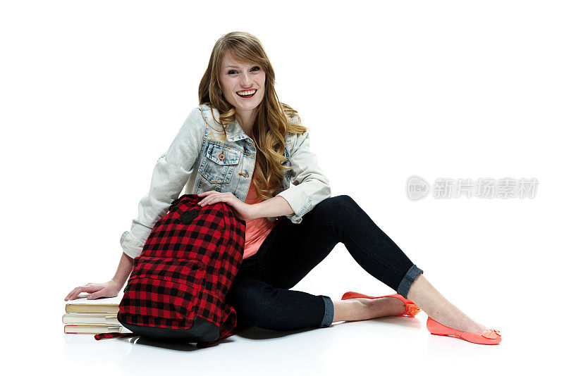 快乐的年轻女子坐在地板上