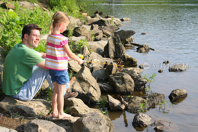 女儿和父亲在湖边钓鱼