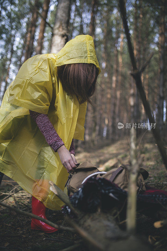 秋天的女性在森林里穿雨衣