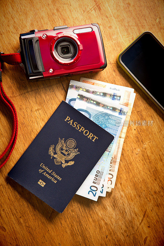 旅游必需品护照，欧元货币，相机和电话的静物生活