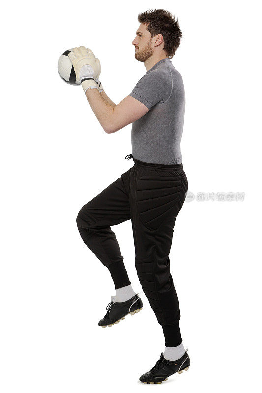 年轻的足球运动员跳球孤立的白色背景