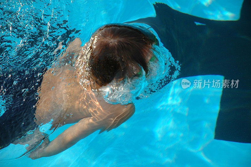 青年游泳运动员在游泳池中浮出水面