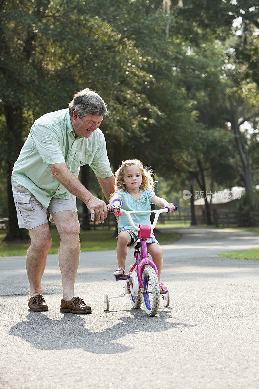 小女孩和爷爷一起骑自行车