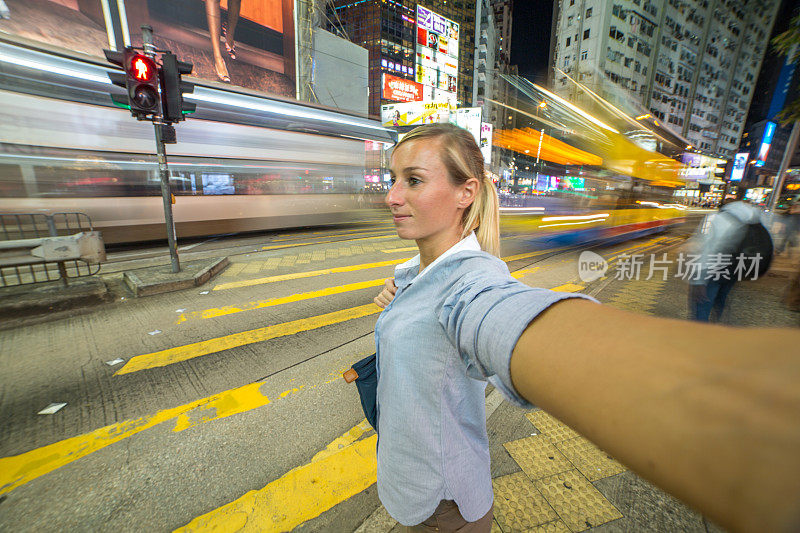 年轻女商人在拥挤的街道上自拍——香港