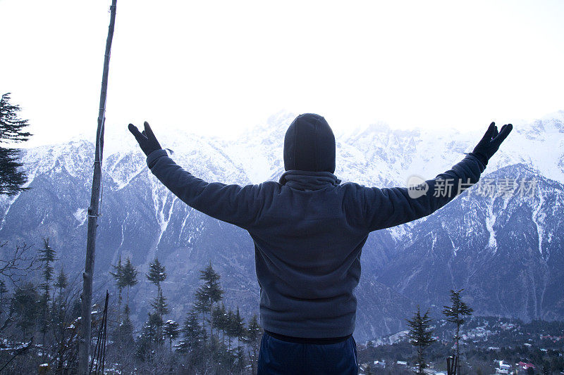 在白雪覆盖的喜马拉雅山上，一个张开双臂的男人