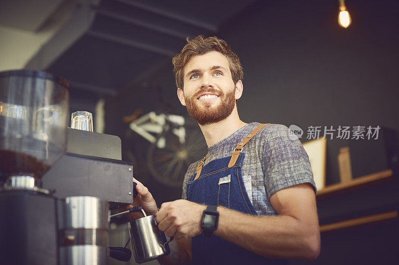 微笑的咖啡师在咖啡馆准备咖啡