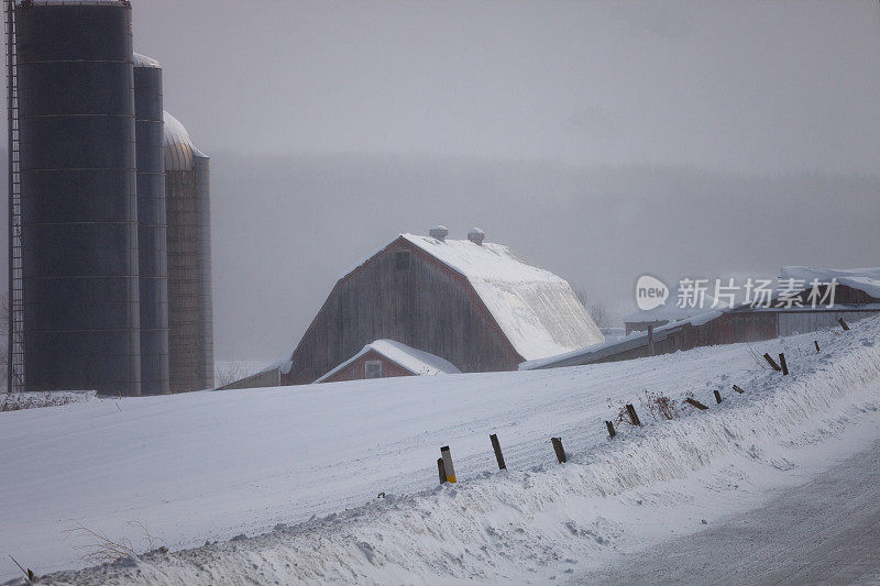 农场建筑埋在吹起的冬雪中