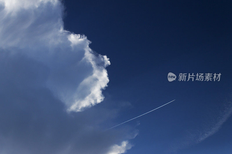 深蓝色的天空，白云和飞机的痕迹