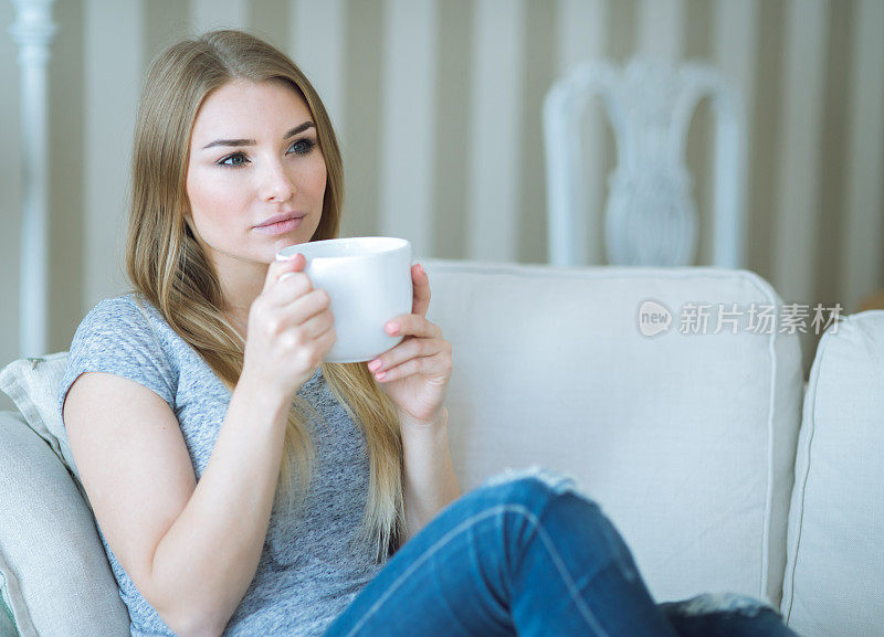 年轻女子在家里用一杯饮料