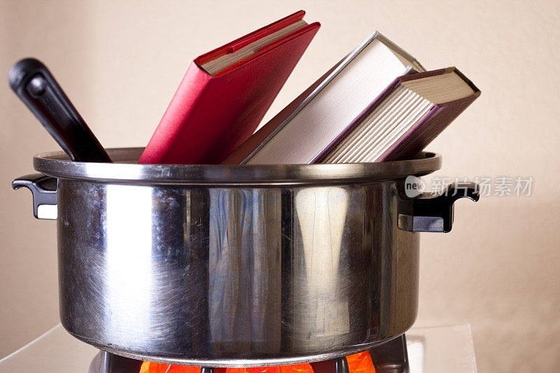 烹饪书。炉子上的不锈钢锅。