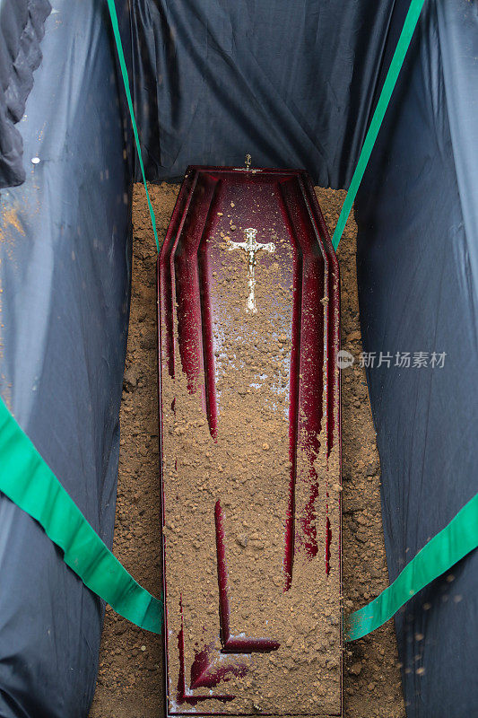 棺材在坟墓。埋在坟墓里的棺材上撒了土。传统的葬礼