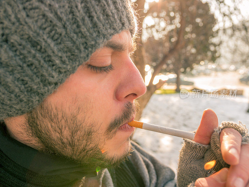 一个年轻人正要点燃一支香烟的特写镜头