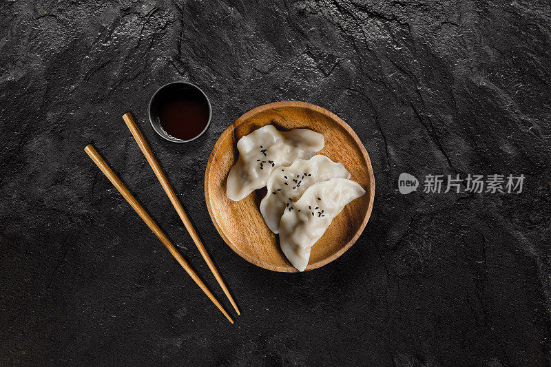 在黑色石板上涂酱油的亚洲水饺。