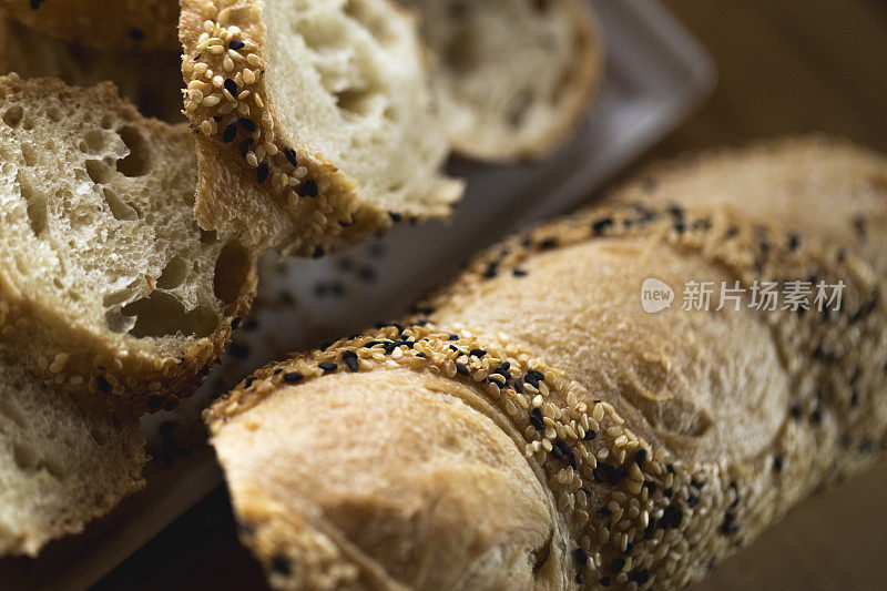 特写切片法棍面包，面包皮上有芝麻。