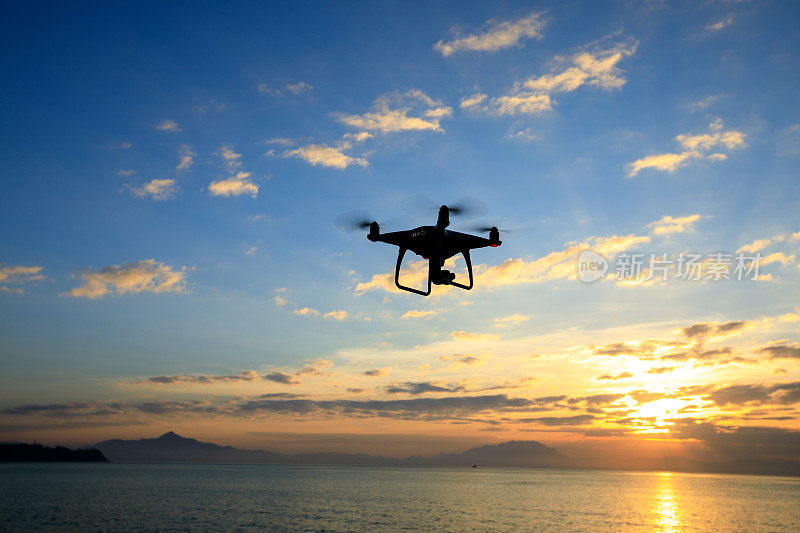 在日出海面上拍摄照片的飞行无人机