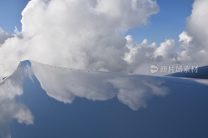 飞机机翼上云朵的倒影