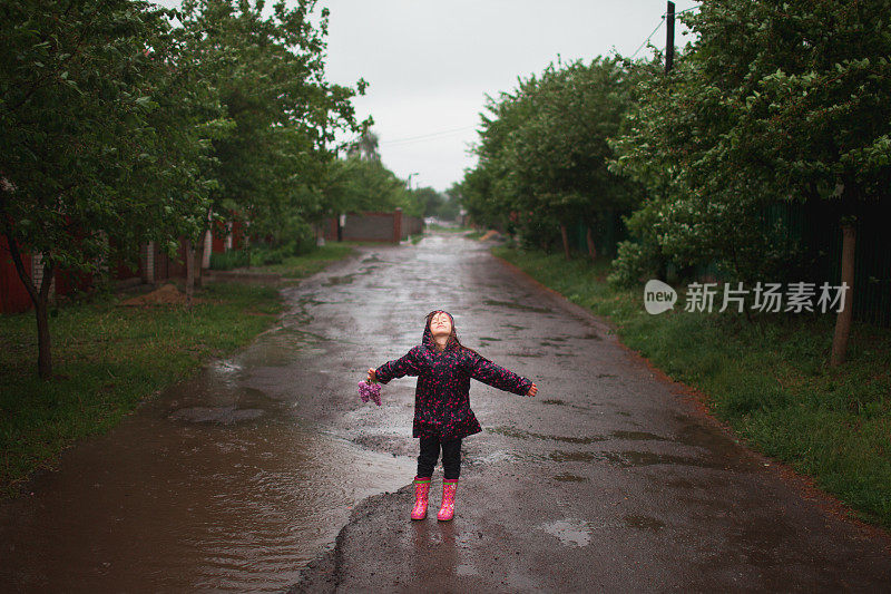 小女孩在雨中行走在乡村