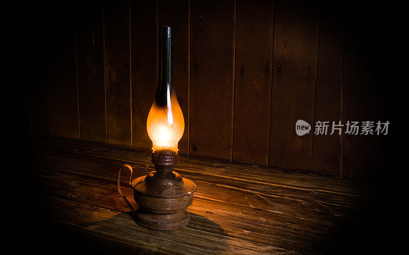 木桌旁放着一盏烧着古董的煤油灯。