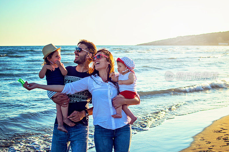 父母和女儿一起在热带阳光沙滩上放风筝