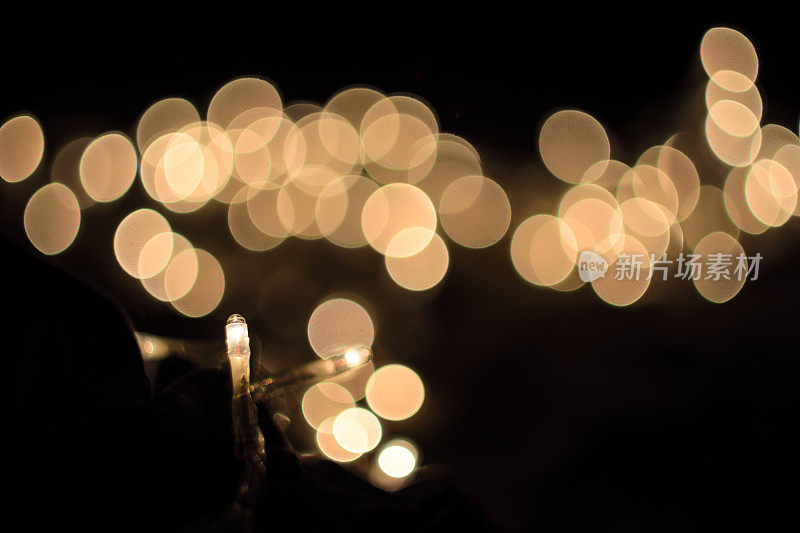 特写白色圣诞灯与旋涡散焦散景在夜间的背景