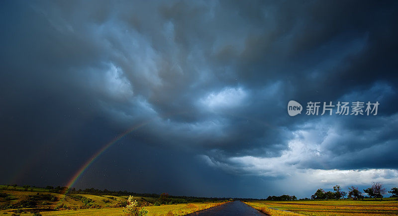 彩虹在田野雨和乌云。