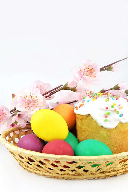 烤蛋糕和糖霜面包和鸡蛋在篮子里的彩色鲜花。