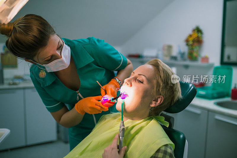 牙医在牙科医生那里检查病人的牙齿。