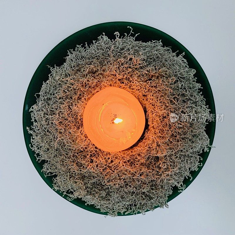 用银白菜做成的圣诞花环，上面燃着蜡烛