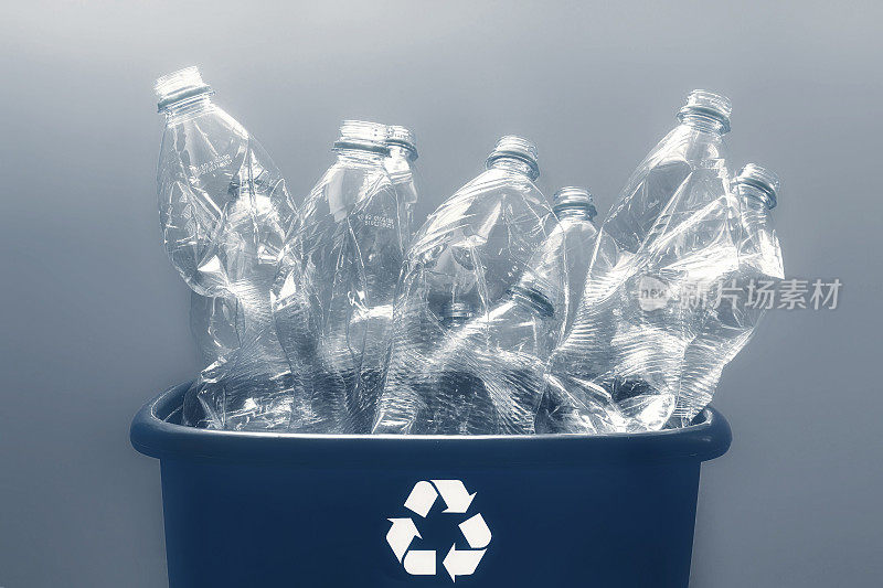 塑料瓶装在带有回收标志的蓝色回收盒内
