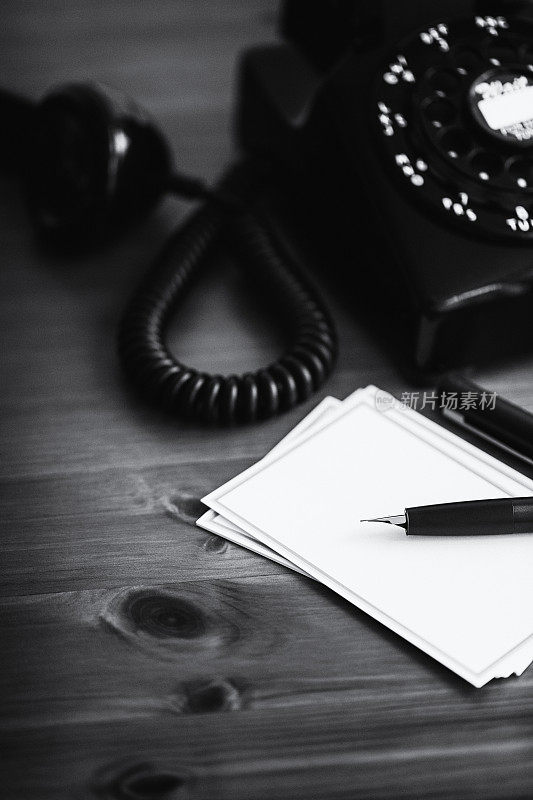 老式五十年代扶轮电话，笔记卡，和钢笔在黑色和白色