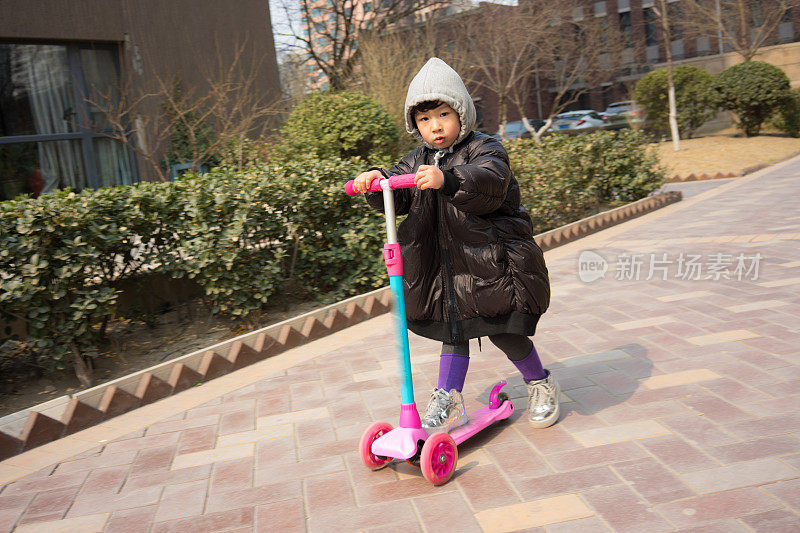 一个小女孩在玩滑板车