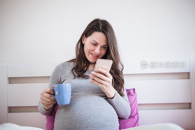 孕妇在卧室里使用手机